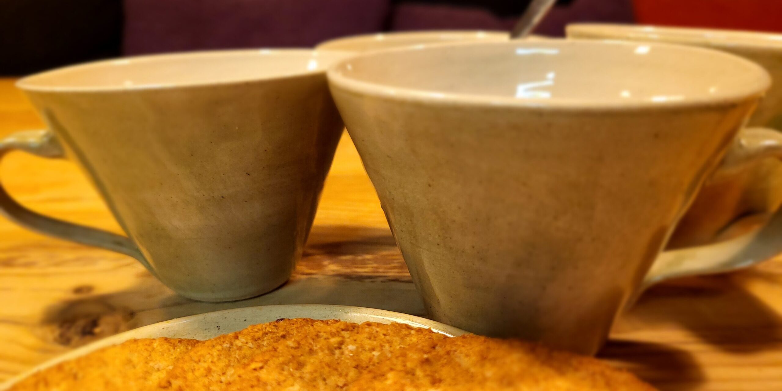 Kaffekopper med kjeks i forgrunnen