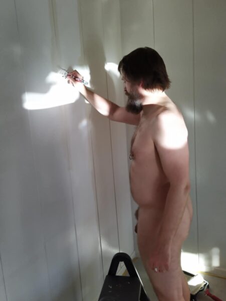 Maler naken i stua